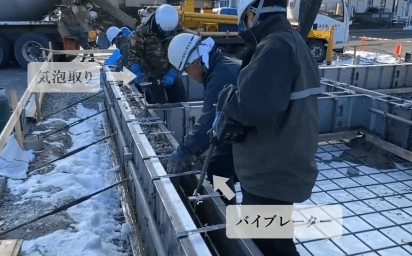コンクリートの締め固めを丁寧に行っている現場